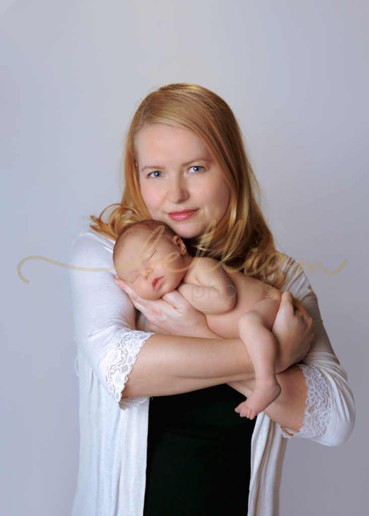 alt="newborn baby girl being held by mom"