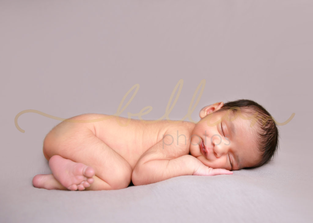 alt="newborn baby boy on a grey blanket in bum up pose"
