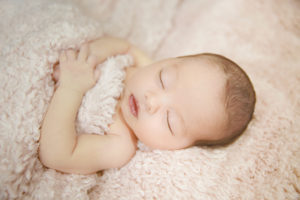 alt="calgary newborn pictures baby girl on a pink furry blanket"