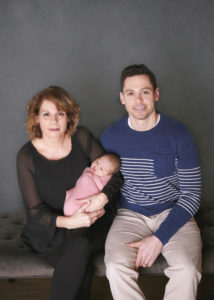 alt="gramma holding newborn baby girl with son"