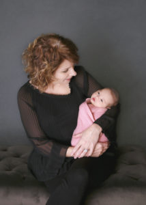 alt="gramma holding newborn baby girl"