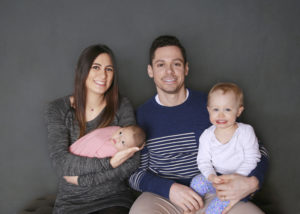 alt="family of four mom holding newborn baby girl"