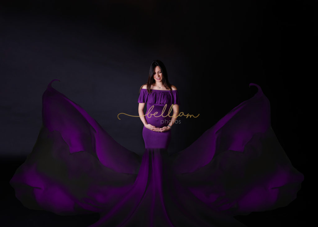alt"pregnant lady in a purple dress with fabric tossed to the side"