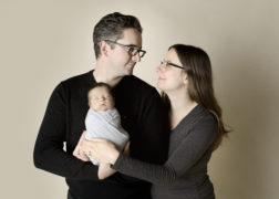 couple looking at each other while holding newborn baby