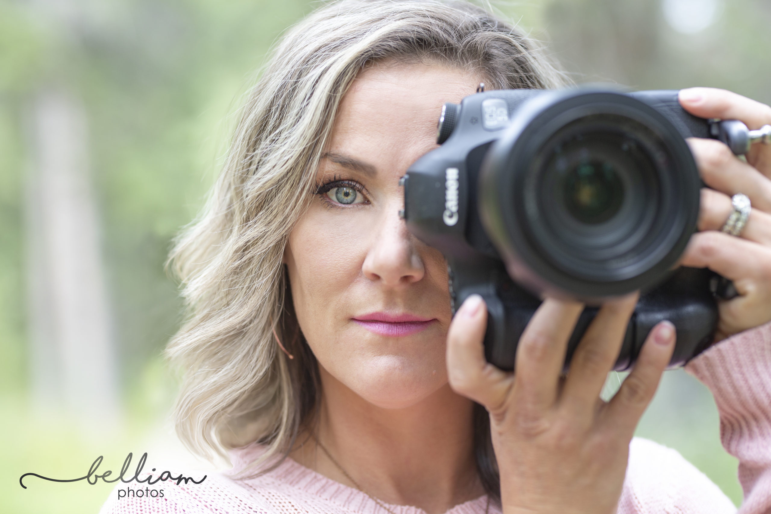 Blonde photographer wendy goetz holding camera up to her face close up photo
