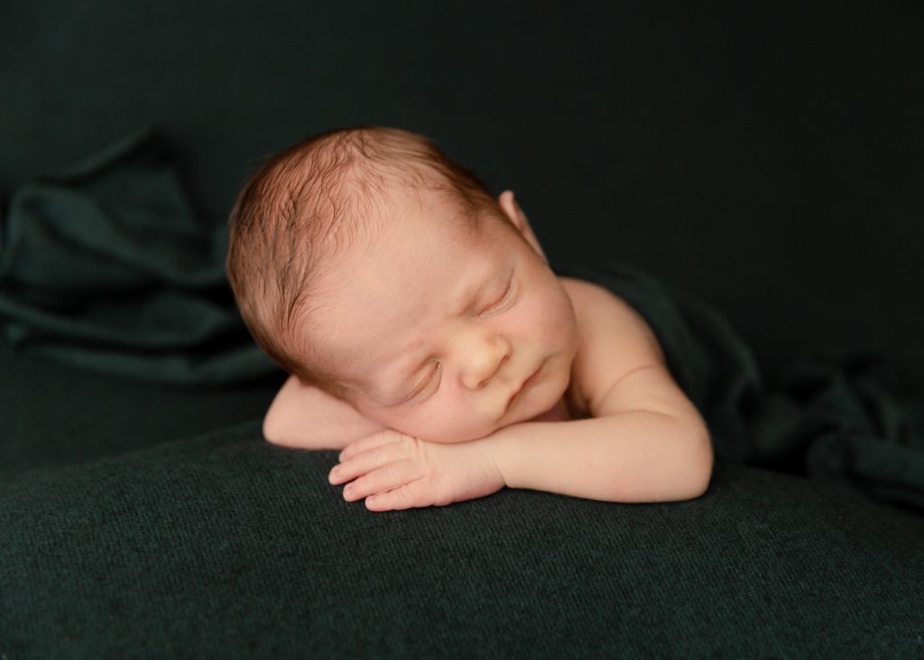 newborn baby boy on green blanket