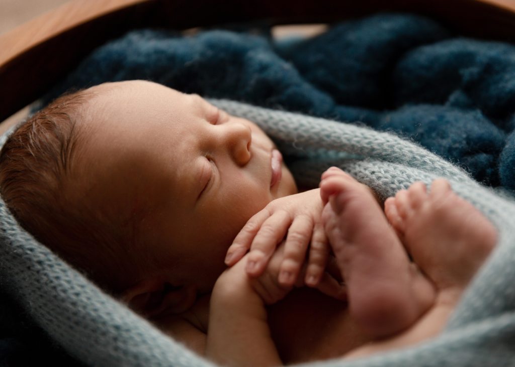 newborn baby boy wrapped in blue