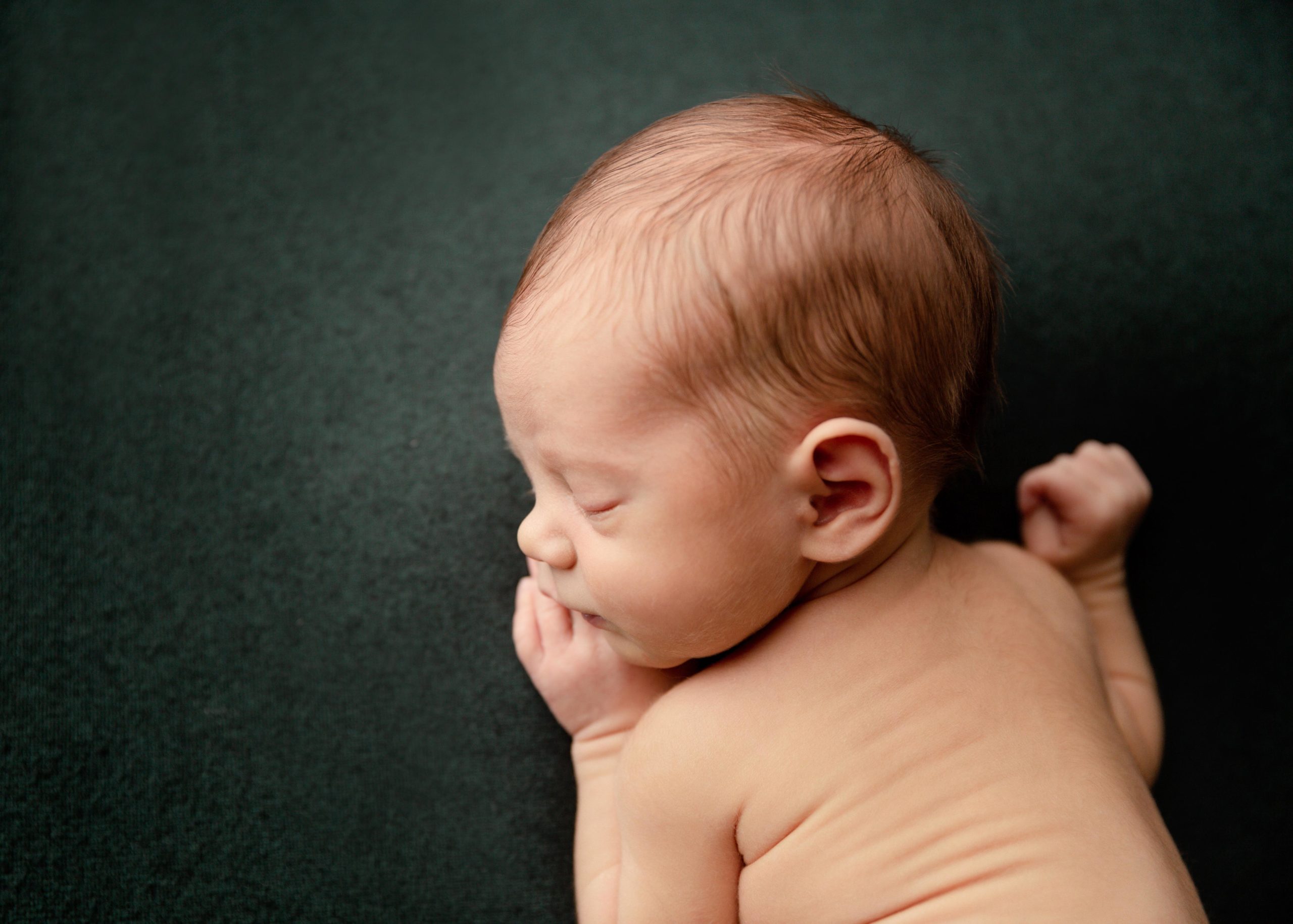 newborn baby boy on green blanket