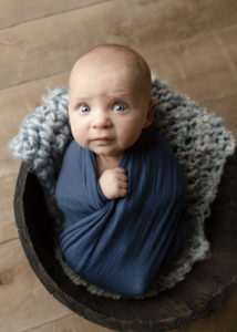 3 month old baby wrapped in a blue wrap in a bucket Calgary baby photographer Belliam Photos
