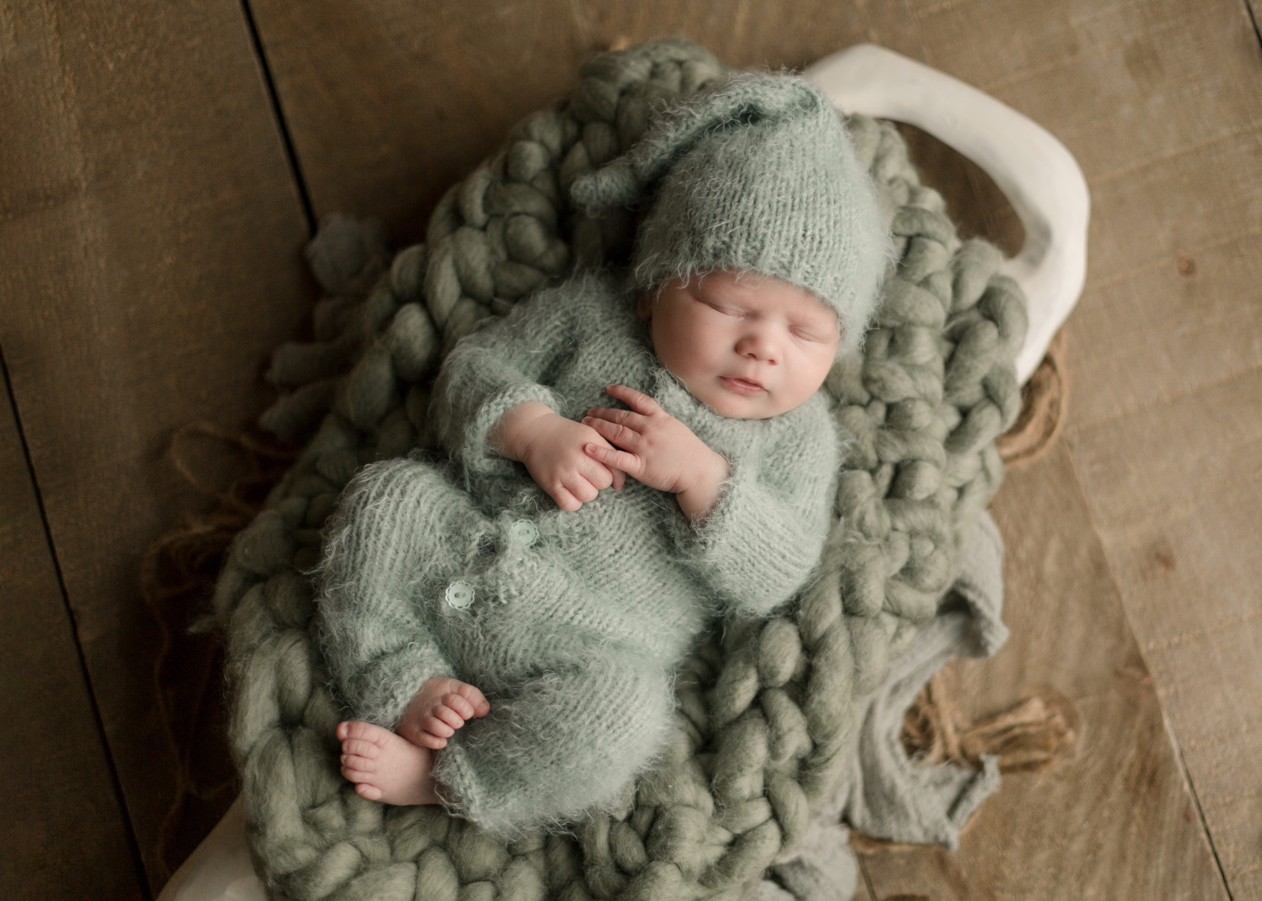newborn in a green knit outfit