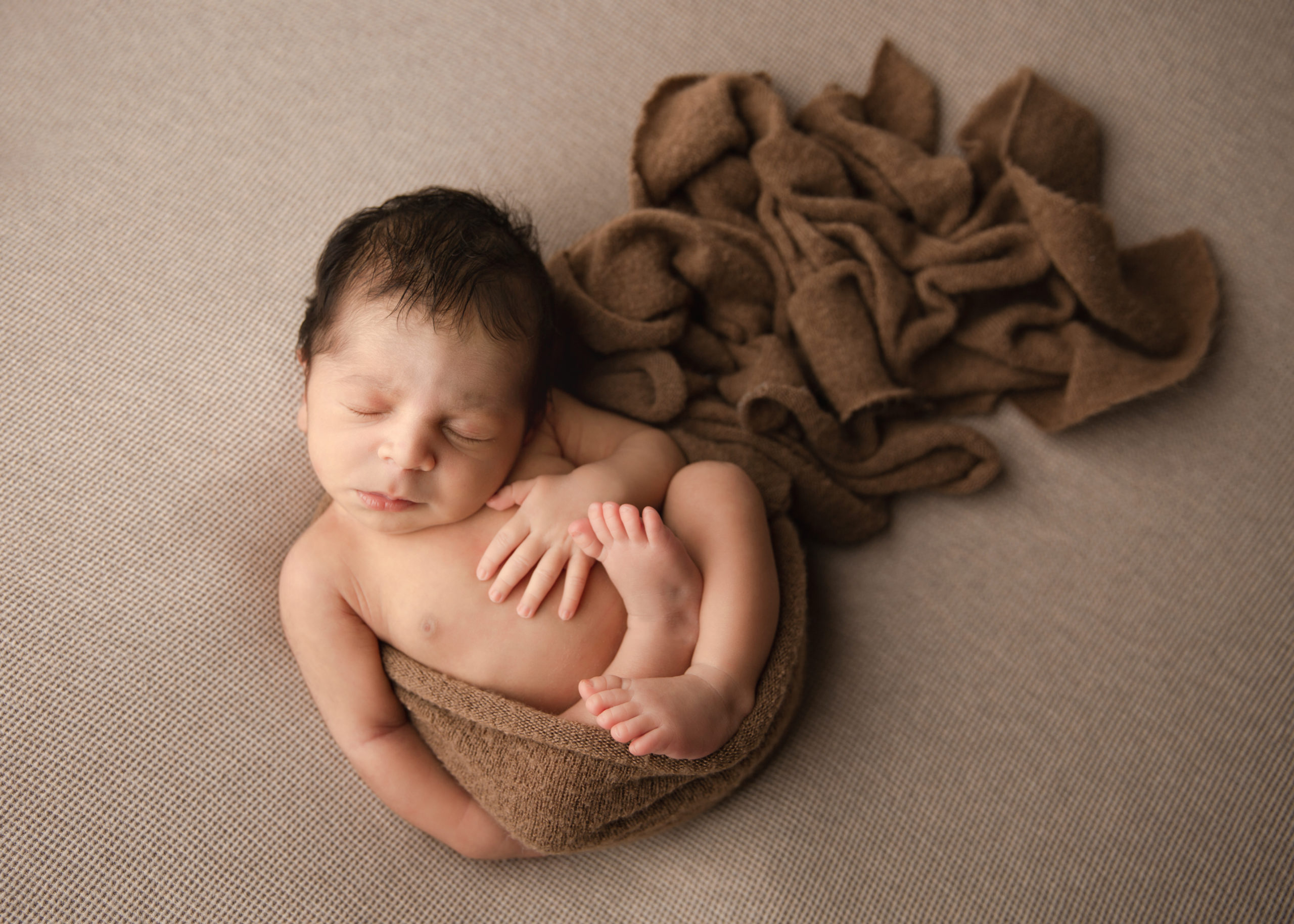 Newborn baby boy on a brown blanket