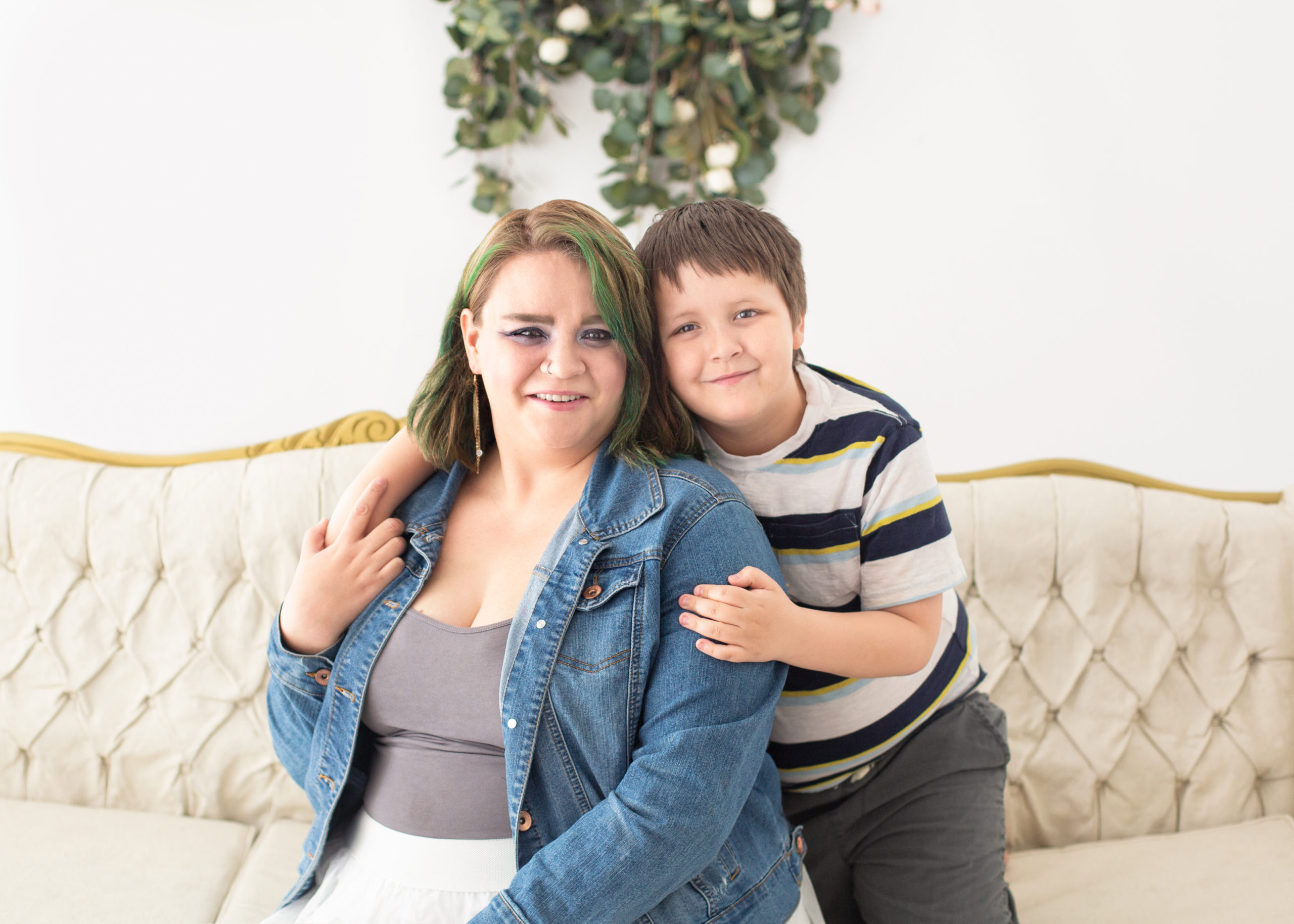 Mom and Son sitting on a couch cuddling for a photo