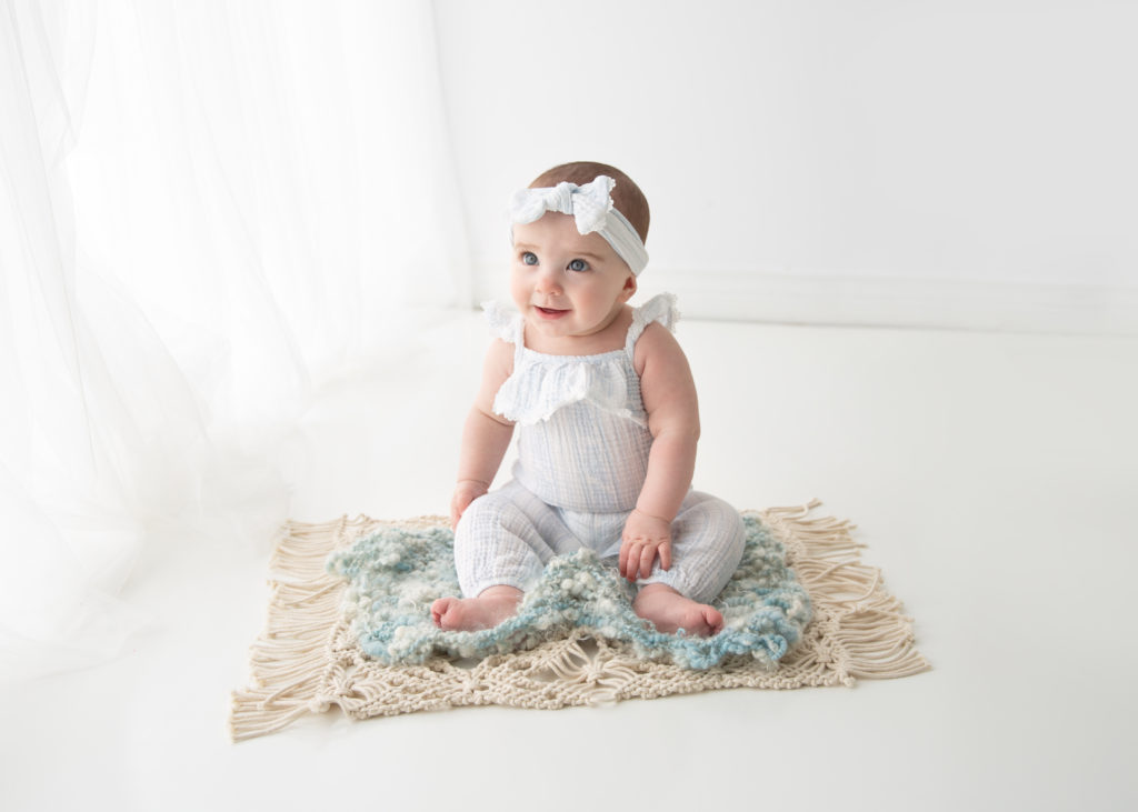 6 month old baby sitting on floor smiling photographed by Belliam Photos