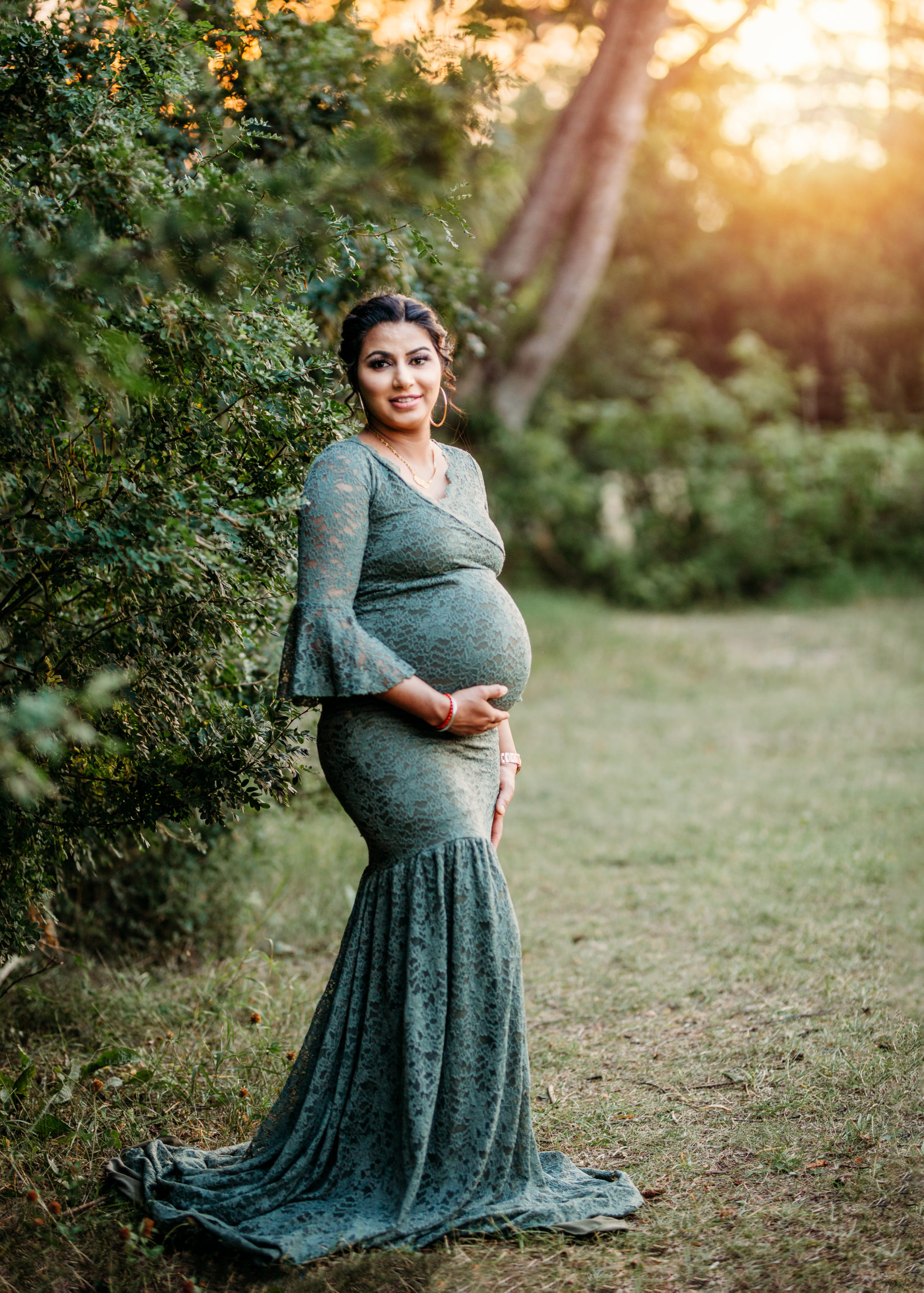 Maternity Photo of a beautiful mama to be in a green lace gown at sunset